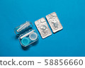 Blue color pair of contact lenses in blisters with blue contact lens case and tweezers on blue background 58856660
