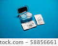 Blue color pair of contact lenses in blisters with blue contact lens case and tweezers on blue background 58856661