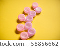 Pink contact lens cases on yellow background 58856662