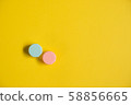 Pink blue contact lens cases on yellow background 58856665