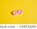 Pink contact lens cases on yellow background 58856666