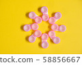 Pink contact lens cases on yellow background in flower shape 58856667