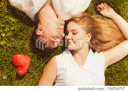 Man and woman lying on grass having date 58856757