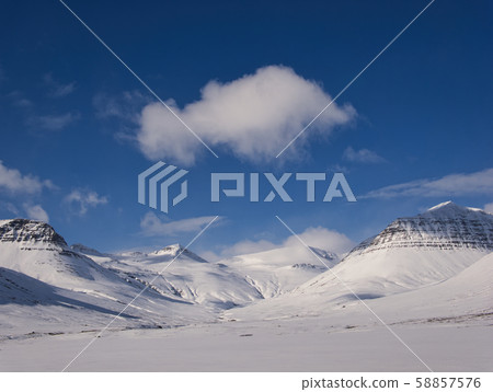 Snow-covered mountain landscape with single clouds 58857576