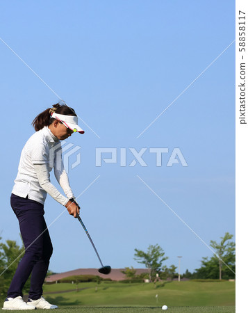 Woman hitting the tee shot Woman hitting the tee shot 58858117