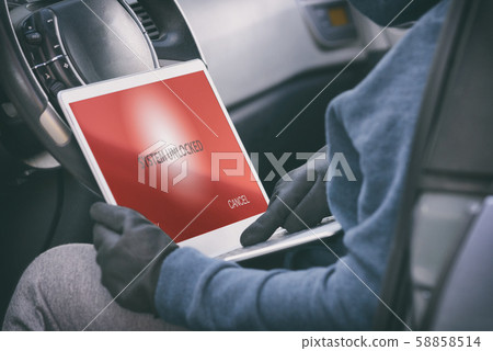 Hooded thief tries to break the car's security 58858514