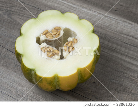 Half of ripe fresh melon with seeds on wooden background. Half of ripe fresh melon with seeds on wooden background. 58861320