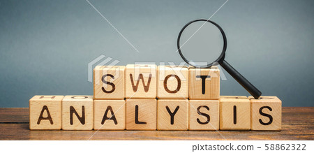 Wooden blocks with the word SWOT analysis and a magnifying glass. The method of strategic business planning. Strengths, weaknesses, opportunities, threats. Business competition or project planning 58862322