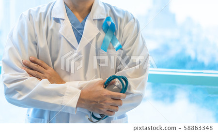 Prostate cancer blue awareness ribbon for men health concept in November with light blue bow color on medical doctor lab gown with stethoscope Prostate cancer blue awareness ribbon for men health concept in November with light blue bow color on medical doctor lab gown with stethoscope 58863348