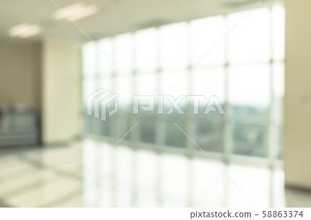 Blur background interior view looking out toward to empty office lobby and entrance doors and glass curtain wall 58863374