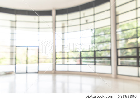 Blur background interior view looking out toward to empty office lobby and entrance doors and glass curtain wall Blur background interior view looking out toward to empty office lobby and entrance doors and glass curtain wall 58863896
