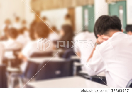 Blur school background back view university students writing answer doing exam in classroom 58863957