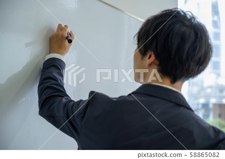 Man writing on whiteboard Man writing on whiteboard 58865082