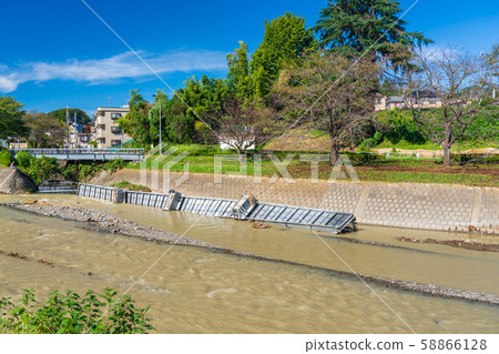 A typhoon passing over a humanitarian bridge washed away by water increase 58866128