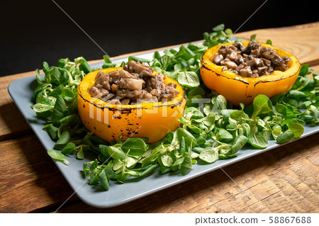 Peppers stuffed with champignons with lettuce on wooden table Peppers stuffed with champignons with lettuce on wooden table 58867688