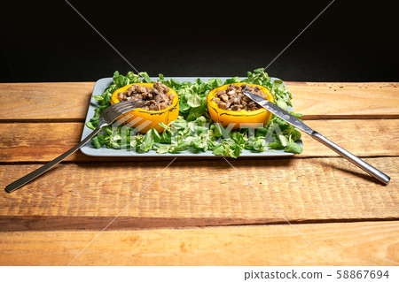 Peppers stuffed with champignons with lettuce on wooden table Peppers stuffed with champignons with lettuce on wooden table 58867694