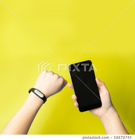 Female hands hold a smartphone and a fitness 58870745