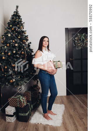 Woman with naked pregnant belly holding little Woman with naked pregnant belly holding little 58870992