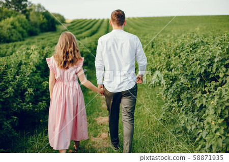 Beautiful couple spend time on a summer field Beautiful couple spend time on a summer field 58871935