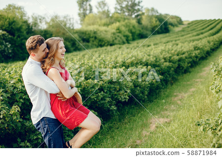 Beautiful couple spend time on a summer field Beautiful couple spend time on a summer field 58871984