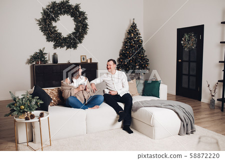 Couple sitting on sofa with tea cups in hands. Couple sitting on sofa with tea cups in hands. 58872220