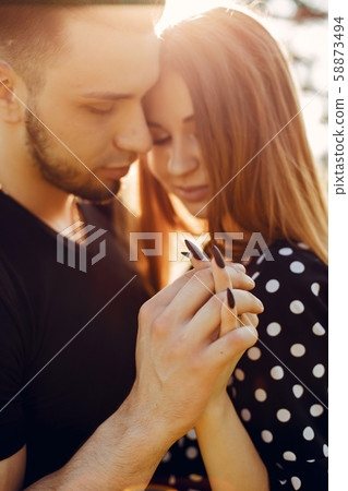 Beautiful couple spend time in a summer park Beautiful couple spend time in a summer park 58873494