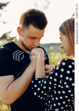 Beautiful couple spend time in a summer park Beautiful couple spend time in a summer park 58873573