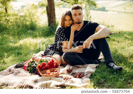 Beautiful couple spend time in a summer field Beautiful couple spend time in a summer field 58873704