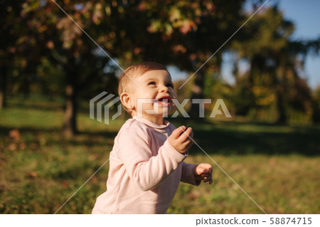 Adorable little girl walking in the parl in autumn weather. Happy baby girl 58874715