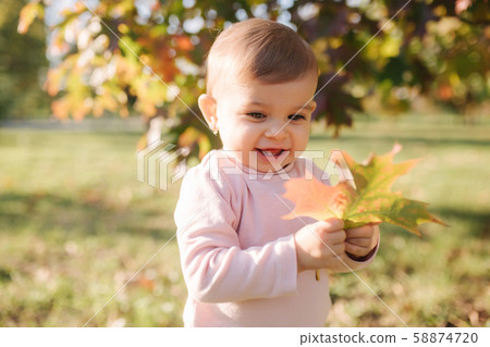 Adorable little girl walking in the parl in autumn weather. Happy baby girl 58874720