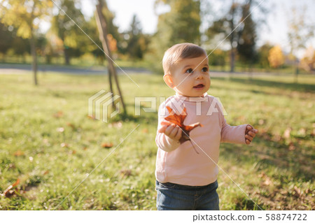 Adorable little girl walking in the parl in autumn weather. Happy baby girl 58874722