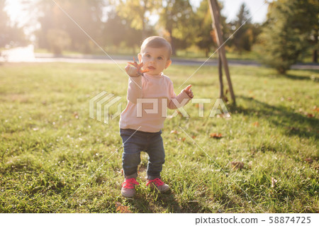 Adorable little girl walking in the parl in autumn weather. Happy baby girl 58874725