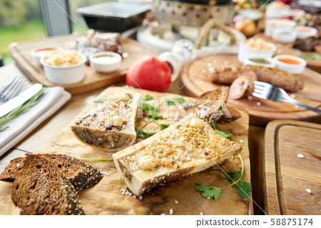 Beef bone marrow with chimichurri sauce and toasted bun. Barbecue restaurant menu. Many different Beef bone marrow with chimichurri sauce and toasted bun. Barbecue restaurant menu. Many different 58875174