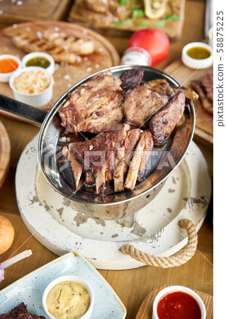 Various grilled meat set heated on coals. Barbecue restaurant menu. Many different food on the table Various grilled meat set heated on coals. Barbecue restaurant menu. Many different food on the table 58875225