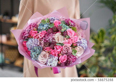 Beautiful bouquet of mixed flowers in womans hands. the work of the florist at a flower shop 58875288