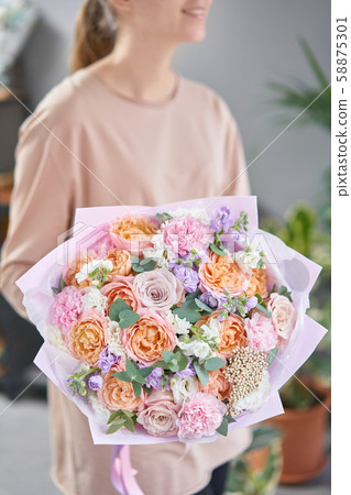 Beautiful bouquet of mixed flowers in womans hands. the work of the florist at a flower shop 58875301