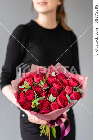 Beautiful bouquet of mixed flowers in womans hands. the work of the florist at a flower shop 58875395