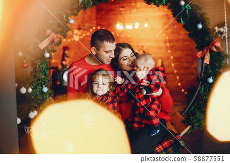 Family sitting at home near christmas tree Family sitting at home near christmas tree 58877551