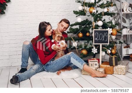 Cute family at home near Christmas tree Cute family at home near Christmas tree 58879587