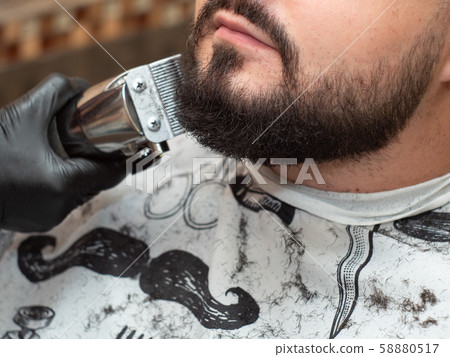 Male in barbershop, close up view. Stylist cutting 58880517