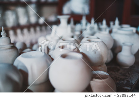 Making ceramic pots and cups from white clay 58882144
