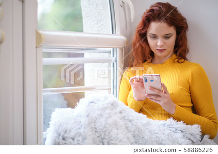 Woman taking a selfie with a smoothie using a 58886226