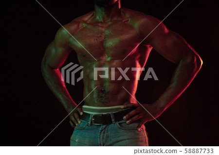 Young african-american basketball player against dark background Young african-american basketball player against dark background 58887733