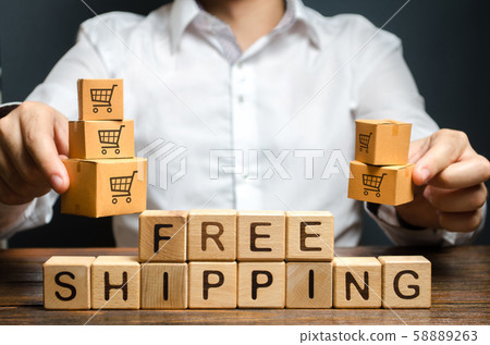 A man holds boxes over the inscription free shipping. Promotions preferential terms for large customers and product groups. Transportation of goods and services, distribution and delivery of orders. A man holds boxes over the inscription free shipping. Promotions preferential terms for large customers and product groups. Transportation of goods and services, distribution and delivery of orders. 58889263