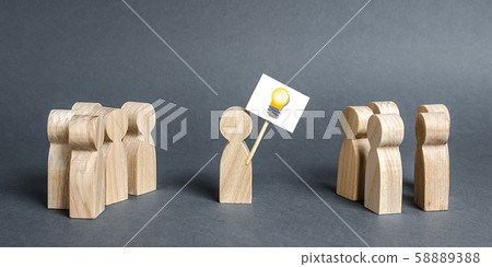 A man with a poster with a picture of the idea bulb refers to a crowd of people. The concept of proposing a new idea and option, a fresh look at the problem and finding a solution. Ambition 58889388