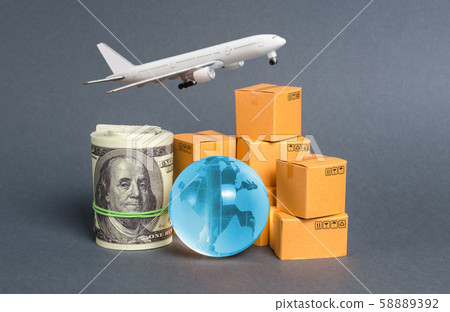 A stack of boxes, airplane a bundle of dollars and a blue planet earth globe. World trade and commodity exchange. commerce traffic trading balance. Import, export, transit of products. 58889392