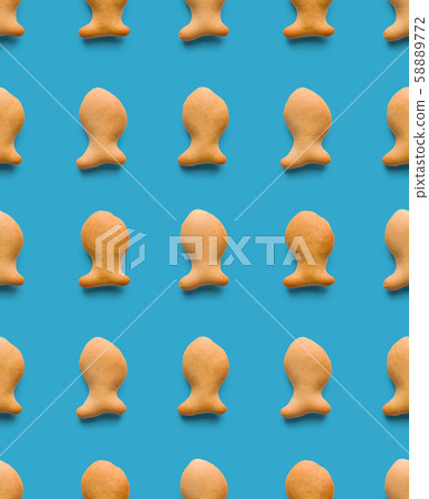 Rounded fresh crispy fish shaped cookies on light blue background. Seamless texture. Top view 58889772