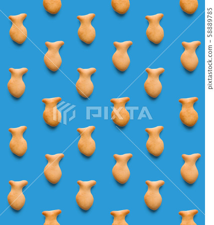 Rounded fresh crispy fish shaped cookies on light blue background. Seamless texture. Top view 58889785