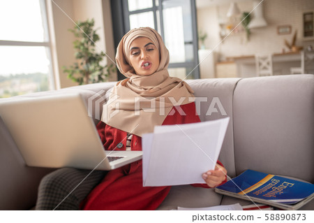 Muslim girl feeling irritated with the amount of work 58890873