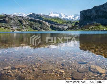 Mountain lake and peaks covered with the snow. Mountain lake and peaks covered with the snow. 58890875